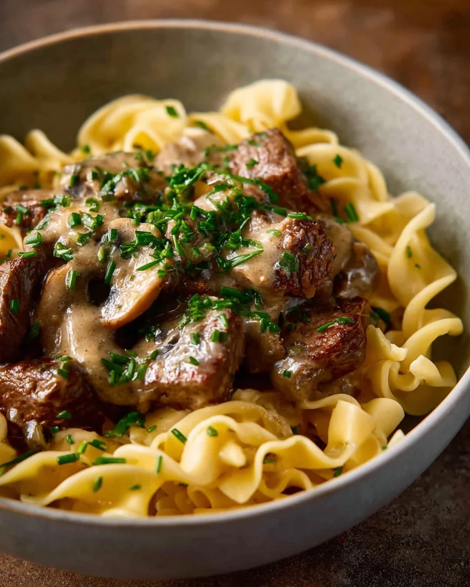 Delicious Beef Stroganoff served over noodles with creamy sauce and tender beef