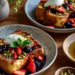 Challah French Toast with mascarpone cheese and fresh berries served on a plate.