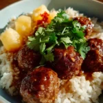 Pineapple glazed meatballs on a plate garnished with parsley