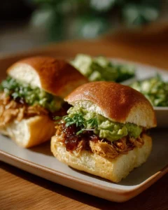 Pulled chicken avocado sliders served on a plate