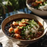 A steaming bowl of Seafood Gumbo with shrimp, fish, and spices