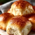 Freshly baked easy homemade dinner rolls on a wooden table.