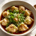 Bowl of easy wonton soup with dumplings and broth.