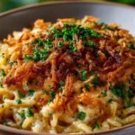 French onion chicken orzo casserole topped with melted cheese and herbs