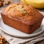 Homemade banana bread loaf with sliced pieces on a wooden board