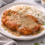 Deliciously fried pork chops served with a side of vegetables