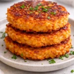 Healthy sweet potato hash browns served on a plate with herbs.