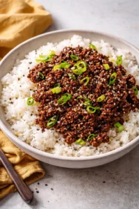 Quick ground beef and rice bowl recipe topped with fresh vegetables