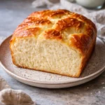 Slice of zero carb yogurt bread on a wooden cutting board