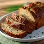 Freshly baked zucchini bread with slices on a wooden board