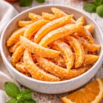 Homemade candied orange peels on a wooden table