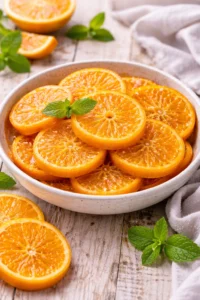 Plate of homemade candied orange slices garnished with mint