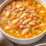 Bowl of easy ham and bean soup garnished with herbs