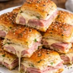 Delicious hot ham and cheese sliders on a platter, perfect for parties.