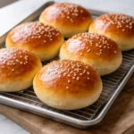 Fluffy homemade burger buns freshly baked on a wooden table