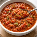 Canned tomato salsa in a jar, fresh ingredients visible