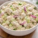 Delicious chicken salad served in a bowl with fresh ingredients and garnishes.