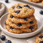 Plate of classic blueberry oatmeal cookies with fresh blueberries