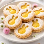 Easter Lemon Linzer Cookies decorated with yellow icing and edible flowers