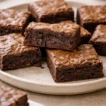 Delicious homemade brownies with chocolate ganache on a wooden table