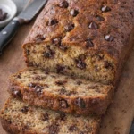Delicious slice of chocolate chip banana bread on a wooden table