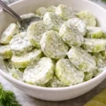 Creamy cucumber salad served in a bowl with fresh herbs