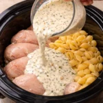 Slow Cooker Chicken and Shells dish served in a bowl with herbs