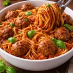 Plate of homemade spaghetti and meatballs topped with parmesan cheese and herbs