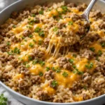 Cheesy ground beef and rice casserole in a dish, ready to serve.