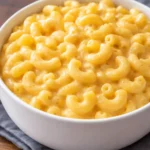Bowl of Simple Mac and Cheese topped with cheese and herbs
