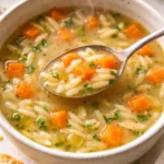 Bowl of delicious homemade orzo soup with fresh herbs and vegetables